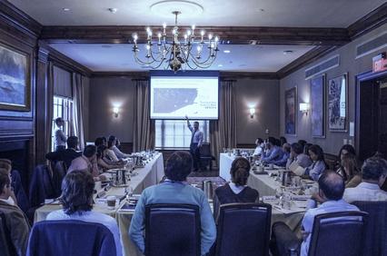 A business meeting in a formal conference room with participants engaged in a presentation.