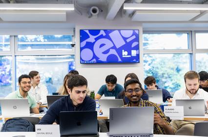 A classroom filled with students working on laptops.