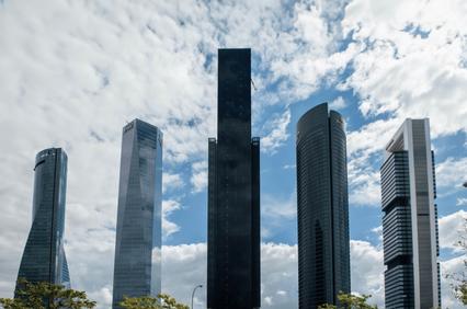 A group of modern skyscrapers under a cloudy sky.