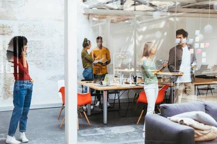 A diverse group of professionals engage in a collaborative meeting inside a modern office space.