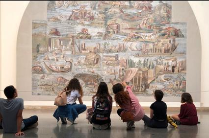 A group of people admiring a large mural in a museum.