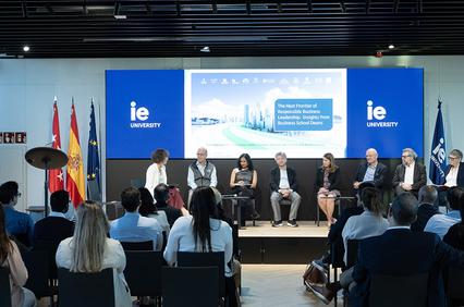 A panel discussion at IE University featuring several speakers and an engaged audience.