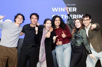 A group of six enthusiastic young adults posing with thumbs up in front of a backdrop that reads 'WINNER GATHERING - Foundation Fellows'.
