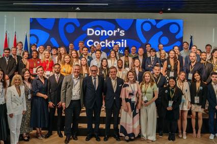 A group of people posing for a photo at a donor's cocktail event.