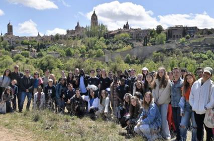 A group of people posing for a photo with a scenic historic city in the background.