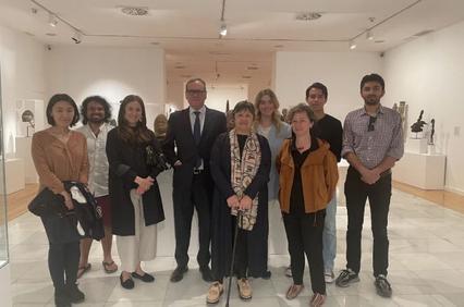 A group of people standing in an art gallery surrounded by sculptures.