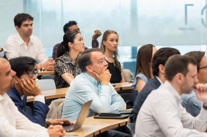 A diverse group of people attentively listening during a presentation.