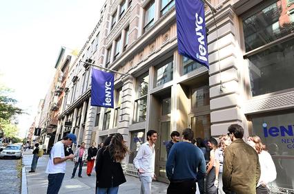 A group of students gathers outside the iNYC New York College building on a sunny day.