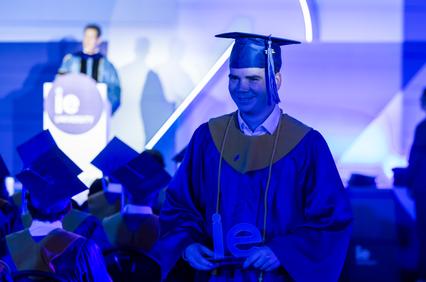 A graduate celebrating during a graduation ceremony.
