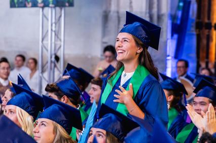 A cheerful graduate celebrating during a graduation ceremony.