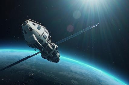 A spacecraft orbiting Earth with sunlight reflecting off its surface.