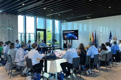 A group of people sitting in a modern conference room with a presentation about space exploration being given.