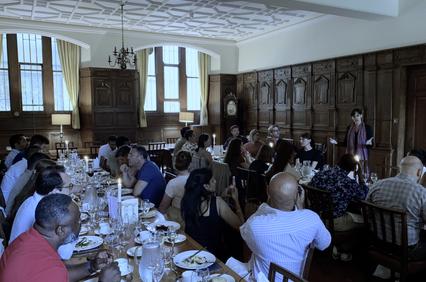 A large group of people gathered around a dining table in an elegant room.
