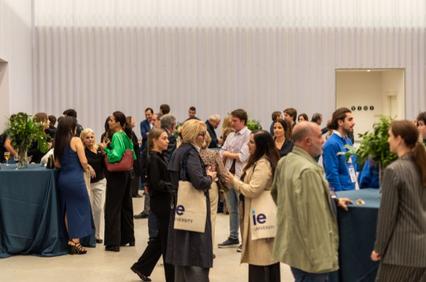 A bustling networking event at an indoor venue with many attendees engaged in conversation.
