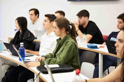 A group of students attentively listening in a classroom setting.