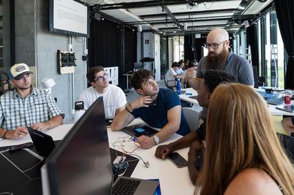 A diverse group of students engaging in a collaborative discussion in a modern classroom.