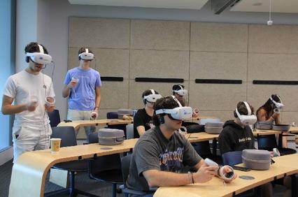 A group of students experiencing virtual reality in a classroom setting.