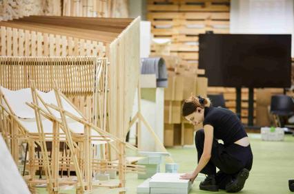 A person is assembling wooden furniture in a workshop.