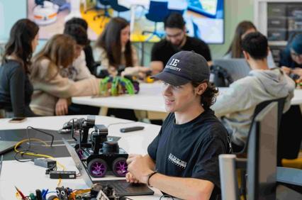 A group of students is collaborating on robotics projects in a modern classroom.