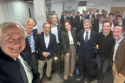 A group of people posing for a photo in a modern office environment.