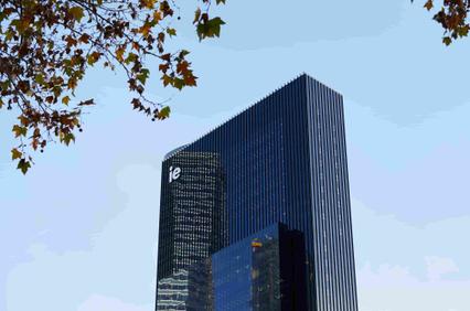 A modern skyscraper featuring glass façades under a clear blue sky.