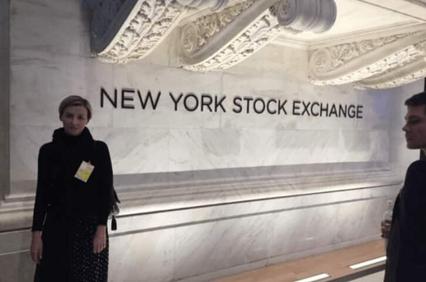 A woman and a man standing inside the New York Stock Exchange building.