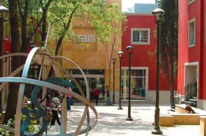 A vibrant urban park featuring colorful buildings, artistic sculptures, and pedestrians enjoying the setting.