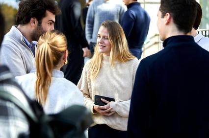 A group of young adults engaging in a conversation outdoors.
