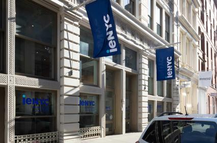 The image shows a building facade with flags displaying the logo of ienYC.