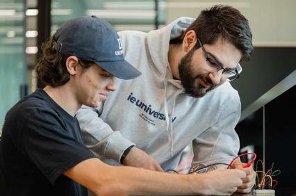 Two students are engaged in a collaborative project involving electronic components.