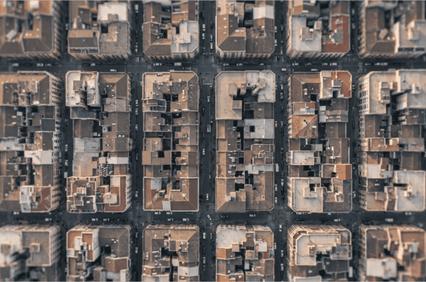 An aerial view of a dense urban area showcasing a grid of buildings and rooftops.