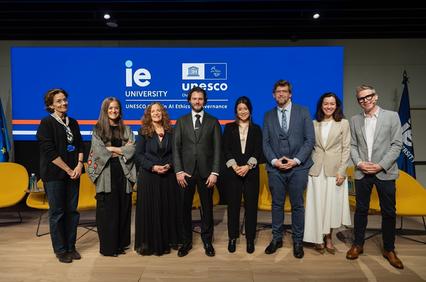 A group of professionals posing for a photo at an event organized by IE University and UNESCO.