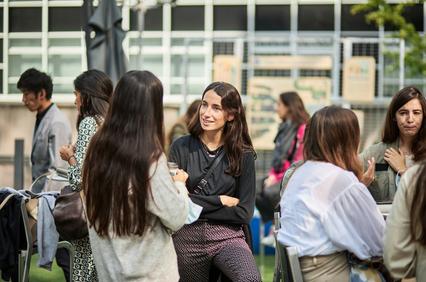 A lively outdoor gathering with several people engaged in conversation.
