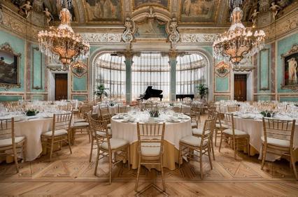 An elegant banquet hall with ornate decor and a grand piano.