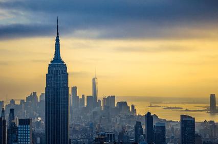 A scenic view of the Empire State Building and lower Manhattan skyline during sunset.