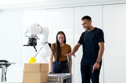 Two IE students looking and speaking about a robot