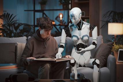 A young person is reading a book while a humanoid robot assists them.