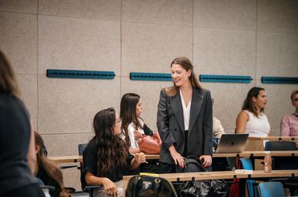 A group of young professionals interacting in a modern classroom setting.