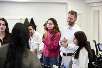 A group of people engaging in a conversation in a well-lit room.