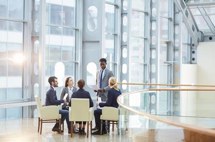 A diverse group of professionals engaged in a meeting in a modern office space.