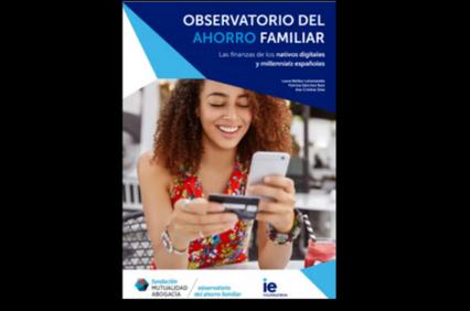 A young woman smiling while using her smartphone and holding another phone in a casual setting.