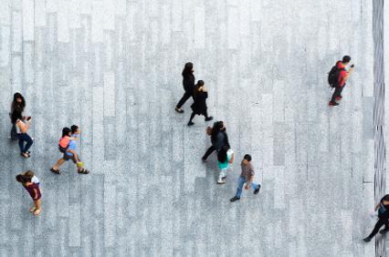 Aerial view of people walking on a textured urban sidewalk.