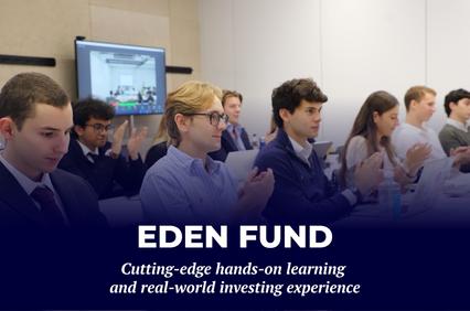 A group of students engaged in a hands-on learning experience related to investing.