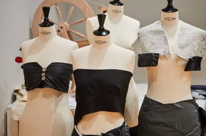 A collection of black clothing designs displayed on mannequins.