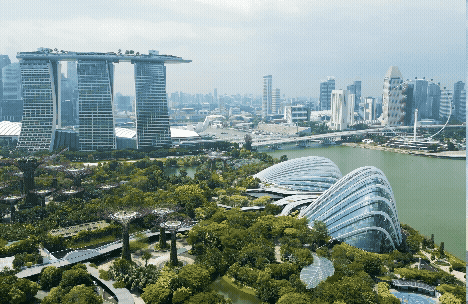 A panoramic view of a modern city with futuristic architecture and lush greenery.