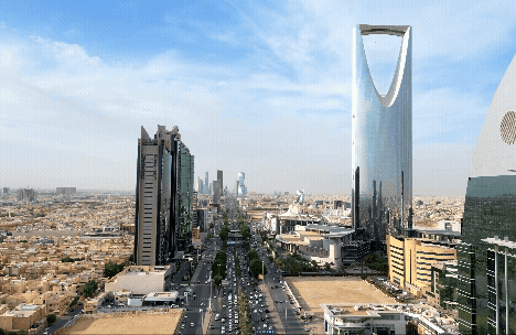 A panoramic view of a modern city skyline with tall buildings and a clear blue sky.