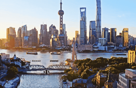 A stunning skyline view of Shanghai with modern skyscrapers by the river during sunset.