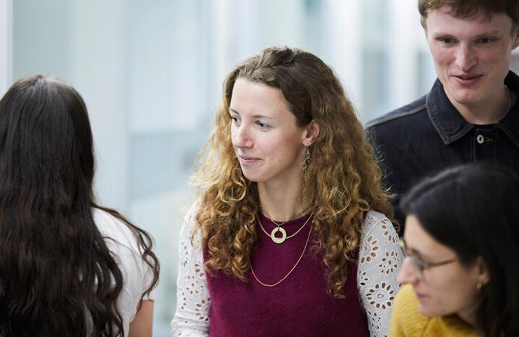 A group of people engaging in a conversation in an office-like setting.