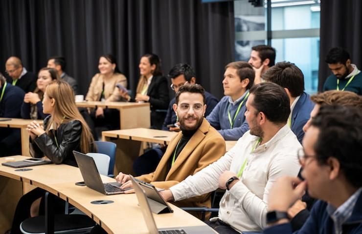 A group of diverse people attending a workshop in a modern conference room.