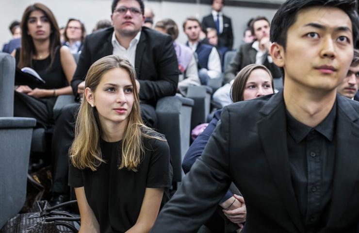 A group of people attentively listening at a conference or seminar.